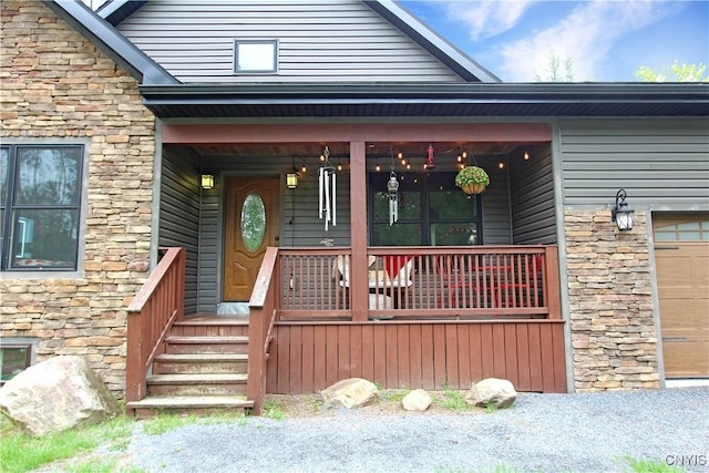 7030 Peckham Rd, Watson, NY 13367 - property entrance featuring stone siding, covered porch, and a garage