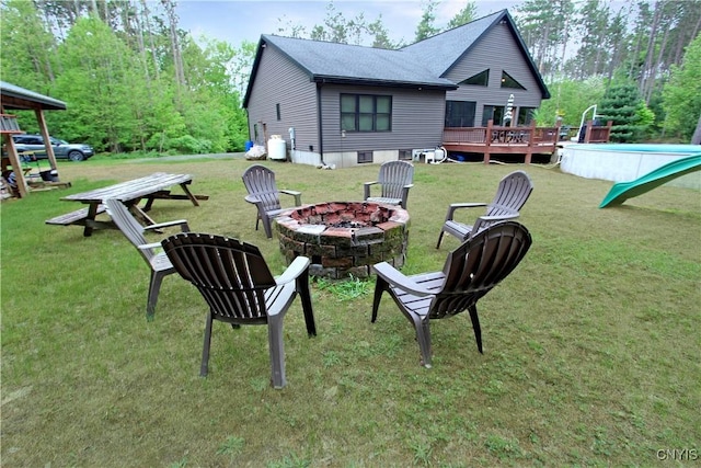7030 Peckham Rd, Watson, NY 13367 - view of grassy yard featuring an outdoor fire pit and a wooden deck