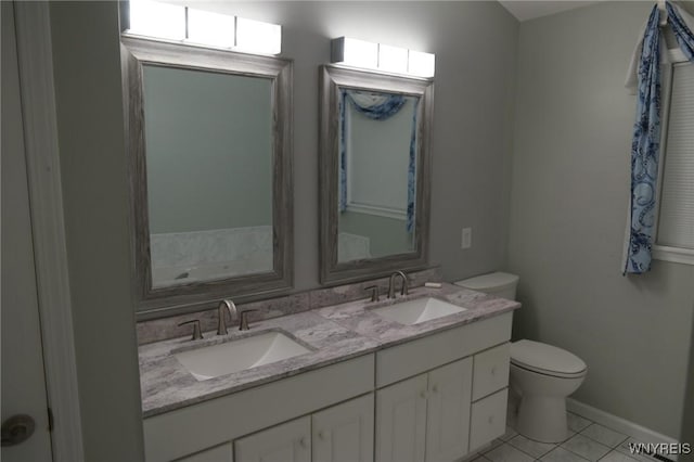 7899 E Ridge Pointe Dr, Manlius, NY 13066 - bathroom featuring toilet, double vanity, tile patterned flooring, and baseboards