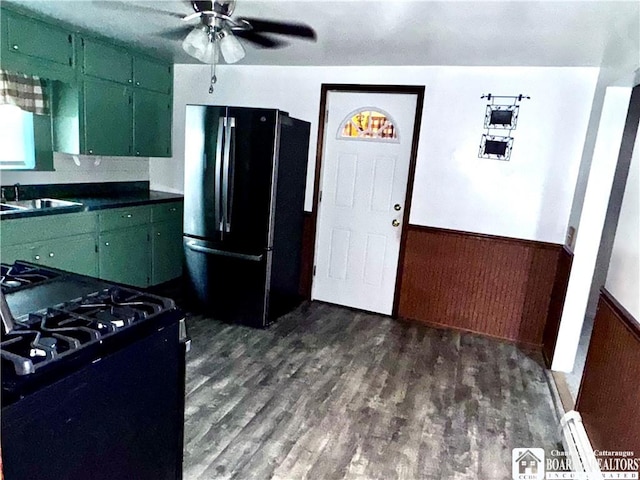 108 S Main St, Evans, NY 14006 - kitchen featuring freestanding refrigerator, gas range oven, green cabinetry, a sink, and a wainscoted wall