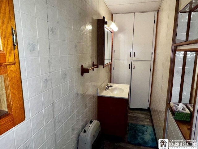108 S Main St, Evans, NY 14006 - bathroom featuring tile walls, vanity, and radiator
