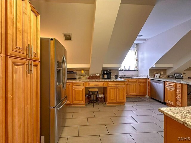 10 Foery Dr Unit 404, Utica, NY 13501 - kitchen featuring appliances with stainless steel finishes, backsplash, light tile patterned flooring, light stone counters, and a sink