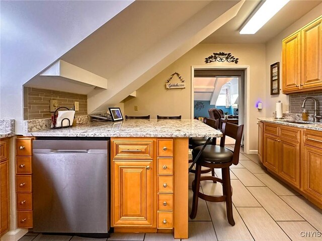 10 Foery Dr Unit 404, Utica, NY 13501 - kitchen with dishwasher, a sink, backsplash, a peninsula, and brown cabinetry