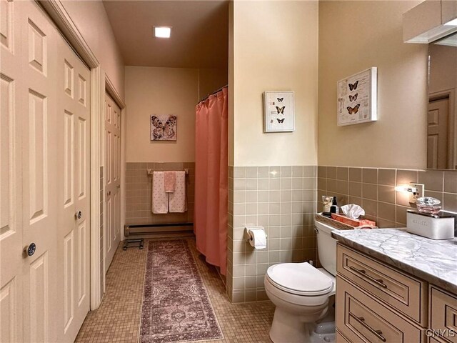 10 Foery Dr Unit 404, Utica, NY 13501 - full bath featuring tile walls, toilet, tile patterned floors, vanity, and a wainscoted wall