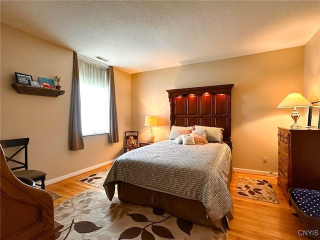 10 Foery Dr Unit 404, Utica, NY 13501 - bedroom with light wood-style floors, a textured ceiling, and baseboards