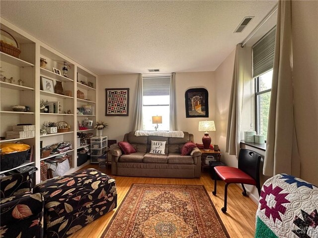 10 Foery Dr Unit 404, Utica, NY 13501 - living area featuring wood finished floors and a textured ceiling
