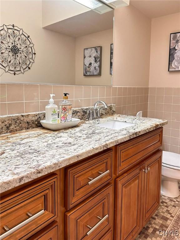 10 Foery Dr Unit 404, Utica, NY 13501 - bathroom featuring vanity, toilet, and tile walls