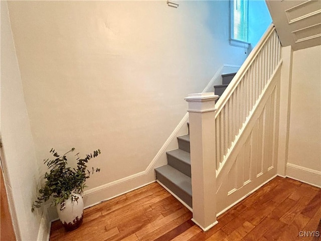 stairway featuring hardwood / wood-style floors and baseboards