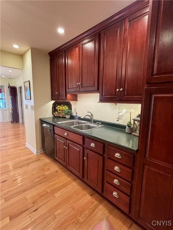 kitchen featuring black dishwasher, dark countertops, light wood finished floors, and recessed lighting