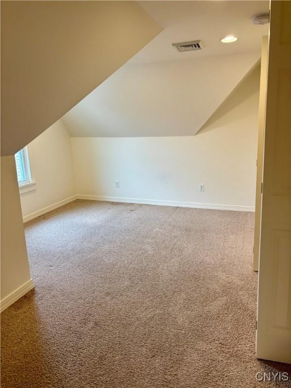 additional living space featuring vaulted ceiling, carpet floors, and baseboards