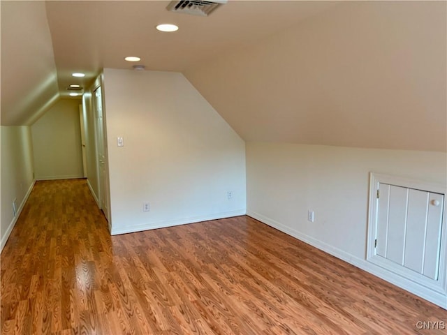 bonus room featuring wood finished floors, vaulted ceiling, baseboards, and recessed lighting