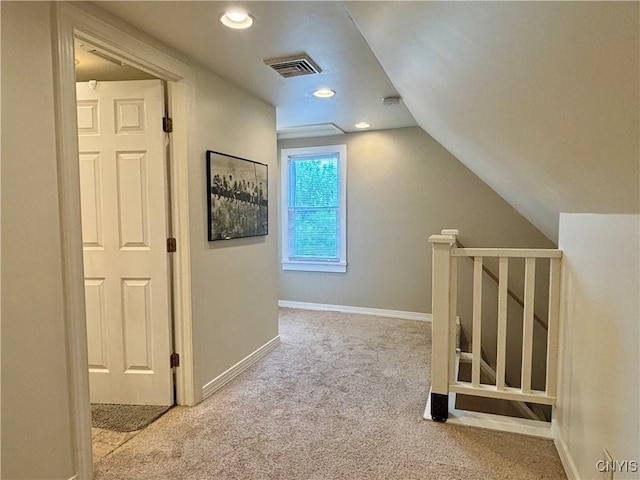 hallway featuring carpet flooring, baseboards, vaulted ceiling, an upstairs landing, and recessed lighting