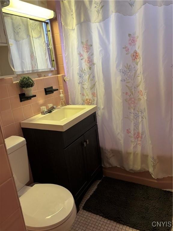 full bath with toilet, vanity, and tile patterned floors