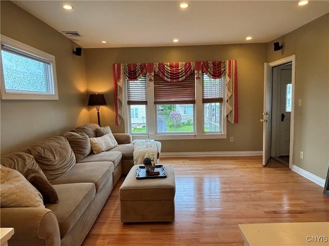 living area featuring healthy amount of natural light, light wood-style floors, recessed lighting, and baseboards