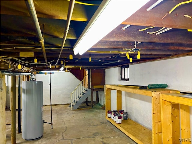 unfinished below grade area featuring water heater and stairs