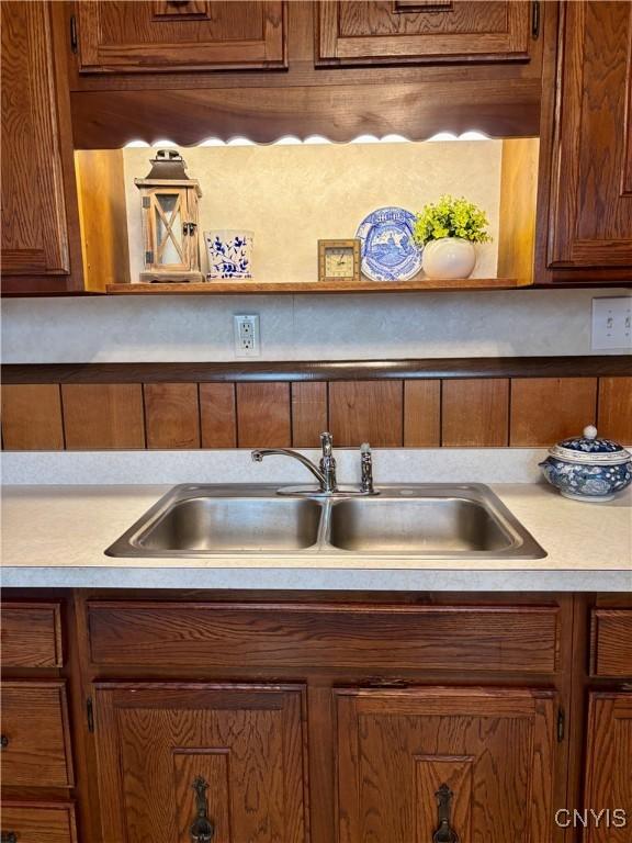 kitchen with a sink, light countertops, and brown cabinets