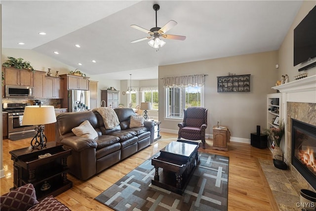 146 Edwards Falls Ln, Manlius, NY 13104 - living room with a tiled fireplace, vaulted ceiling, light wood-style floors, a ceiling fan, and baseboards