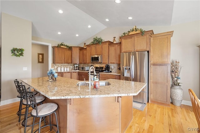 146 Edwards Falls Ln, Manlius, NY 13104 - kitchen featuring stainless steel appliances, lofted ceiling, a breakfast bar area, decorative backsplash, and baseboards