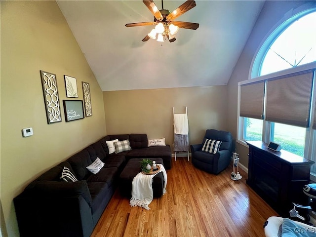 living room featuring vaulted ceiling, plenty of natural light, wood finished floors, and a ceiling fan