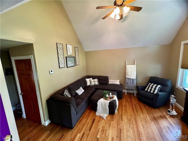 living area featuring lofted ceiling, wood finished floors, a ceiling fan, and baseboards