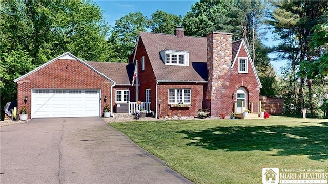 3108 N Main Street Ext, Ellicott, NY 14701 - tudor home featuring a chimney, driveway, an attached garage, a front yard, and brick siding
