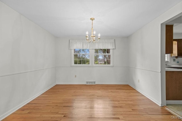 4155 Old Winding Way, Onondaga, NY 13215 - unfurnished dining area with light wood finished floors, a chandelier, and baseboards