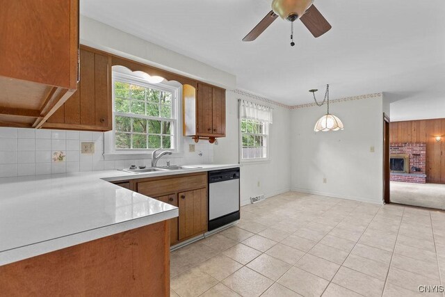 4155 Old Winding Way, Onondaga, NY 13215 - kitchen with dishwashing machine, a sink, brown cabinets, light countertops, and decorative backsplash