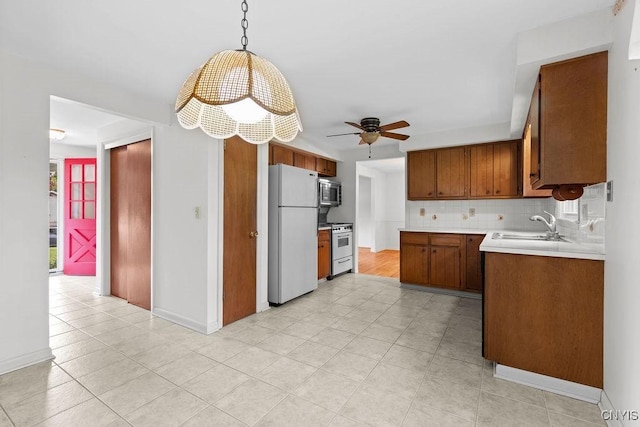 4155 Old Winding Way, Onondaga, NY 13215 - kitchen with freestanding refrigerator, stainless steel microwave, a sink, brown cabinetry, and a ceiling fan