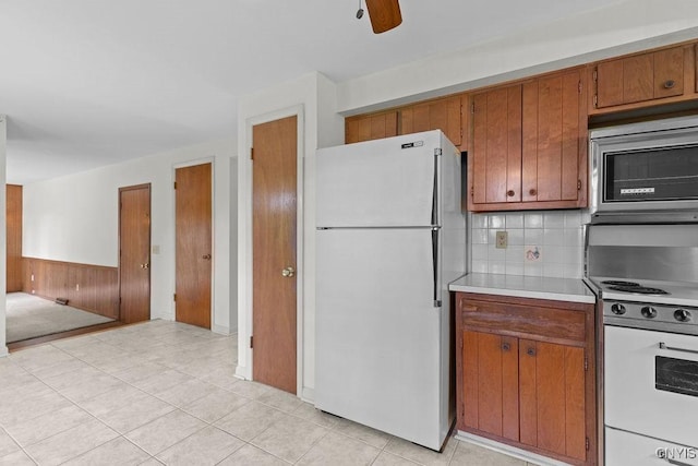 4155 Old Winding Way, Onondaga, NY 13215 - kitchen with white appliances, brown cabinetry, light countertops, backsplash, and ceiling fan