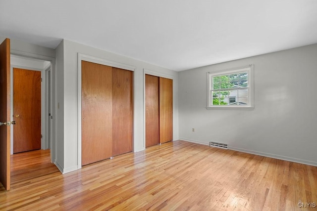 4155 Old Winding Way, Onondaga, NY 13215 - unfurnished bedroom with two closets, wood finished floors, and baseboards