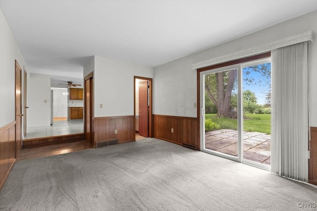 4155 Old Winding Way, Onondaga, NY 13215 - unfurnished living room featuring wainscoting, wooden walls, carpet floors, and a ceiling fan