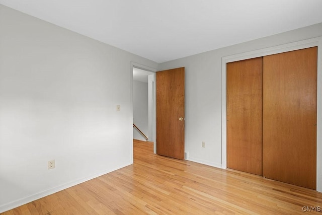 4155 Old Winding Way, Onondaga, NY 13215 - unfurnished bedroom with light wood-style flooring, a closet, and baseboards