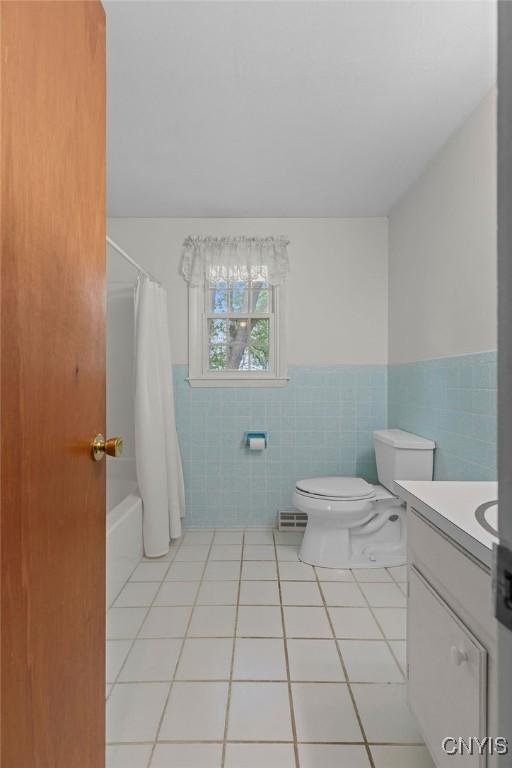 4155 Old Winding Way, Onondaga, NY 13215 - full bath with tile walls, tile patterned flooring, a wainscoted wall, toilet, and vanity