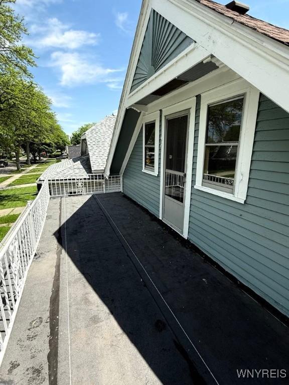 view of side of property with roof with shingles