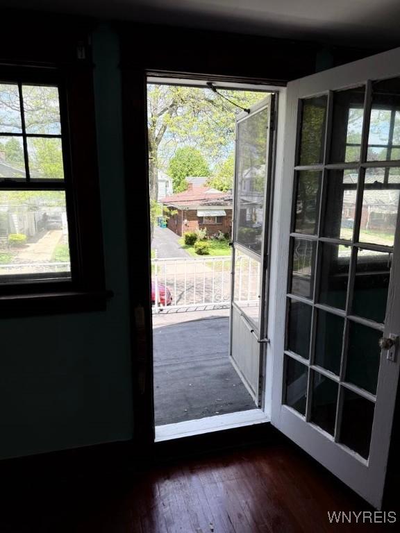 doorway to outside featuring healthy amount of natural light and dark wood-style flooring