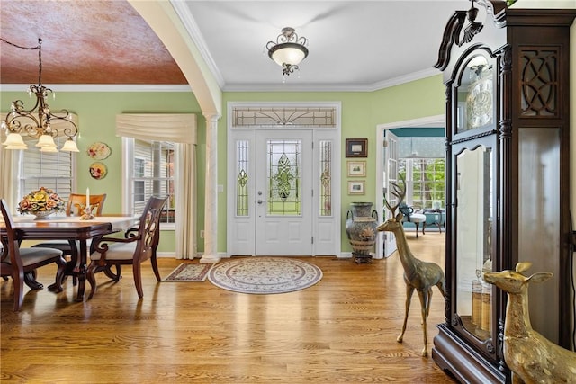 1619 Five Mile Ln Rd, Penfield, NY 14526 - foyer entrance featuring a chandelier, ornamental molding, light wood finished floors, arched walkways, and baseboards