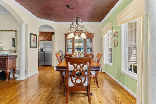 1619 Five Mile Ln Rd, Penfield, NY 14526 - dining area with arched walkways, light wood finished floors, ornate columns, ornamental molding, and a chandelier
