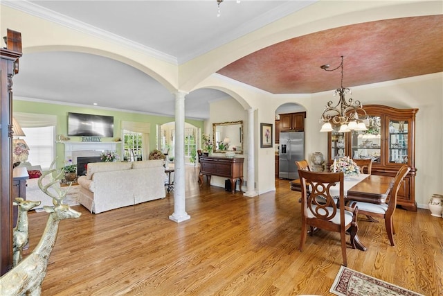 1619 Five Mile Ln Rd, Penfield, NY 14526 - dining space with a fireplace, light wood finished floors, arched walkways, ornamental molding, and baseboards
