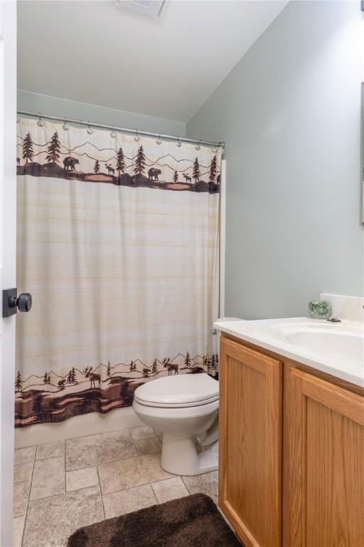 2208 Davis Rd, Corning, NY 14830 - bathroom featuring toilet, vanity, tile patterned floors, and lofted ceiling