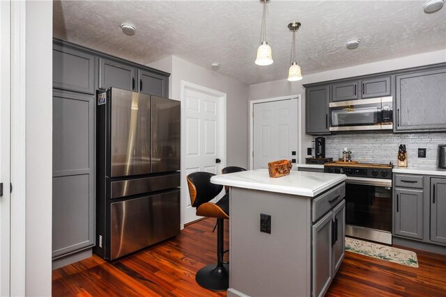 2208 Davis Rd, Corning, NY 14830 - kitchen with stainless steel appliances, gray cabinetry, dark wood finished floors, a center island, and a textured ceiling