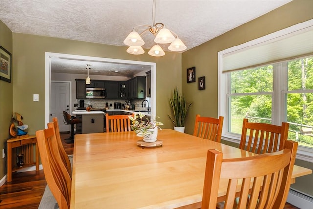 2208 Davis Rd, Corning, NY 14830 - dining space featuring a baseboard heating unit, healthy amount of natural light, a textured ceiling, dark wood-style flooring, and a chandelier