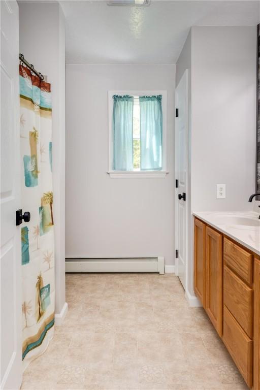 2208 Davis Rd, Corning, NY 14830 - bathroom with baseboard heating, vanity, a shower with curtain, and baseboards