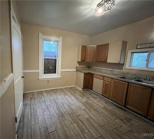 308 Rowland St, Syracuse, NY 13204 - kitchen with a sink, wood finished floors, healthy amount of natural light, and brown cabinetry