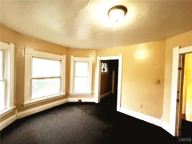 308 Rowland St, Syracuse, NY 13204 - spare room featuring baseboards and dark colored carpet