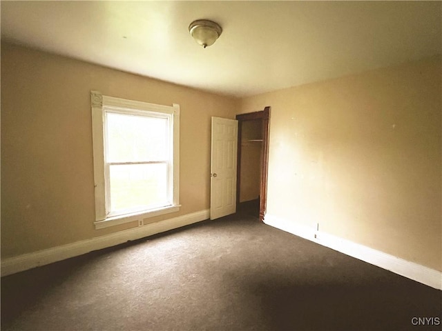 308 Rowland St, Syracuse, NY 13204 - unfurnished bedroom with dark colored carpet, baseboards, and a closet