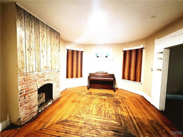 308 Rowland St, Syracuse, NY 13204 - living room featuring a brick fireplace and wood finished floors