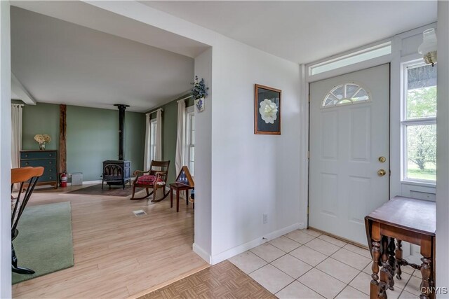 485 E Joseph St, Cape Vincent, NY 13618 - foyer entrance with a wood stove, baseboards, and light wood-type flooring