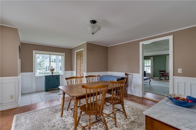 485 E Joseph St, Cape Vincent, NY 13618 - dining room featuring a wainscoted wall, crown molding, and light wood-style flooring