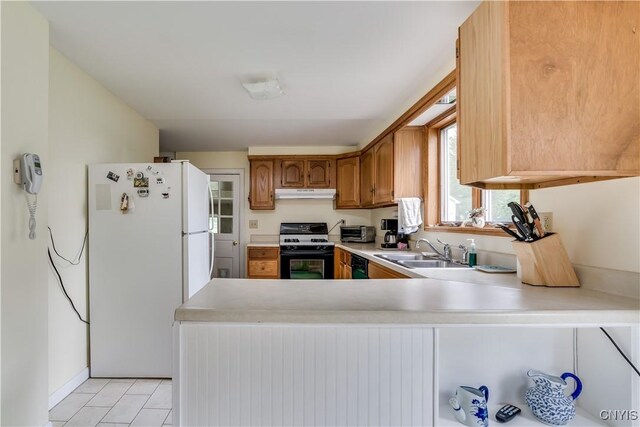 485 E Joseph St, Cape Vincent, NY 13618 - kitchen featuring gas range, freestanding refrigerator, a sink, under cabinet range hood, and light countertops