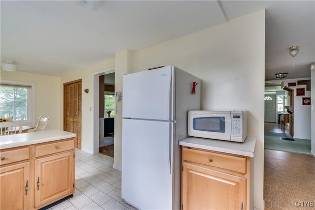 485 E Joseph St, Cape Vincent, NY 13618 - kitchen with white appliances, light countertops, light brown cabinets, and light tile patterned flooring